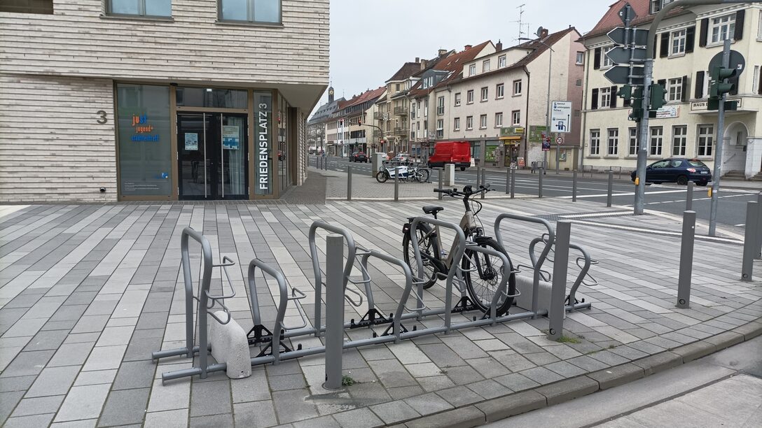 Foto der Fahrradabstellanlage am Friedensplatz, im Hintergrund Wohnhäuser