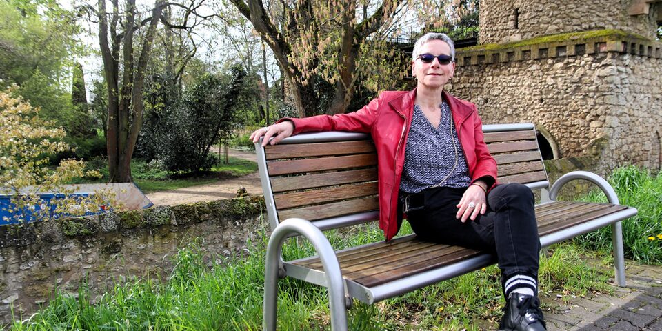 Martina Friedmann auf einer Bank am Mainufer