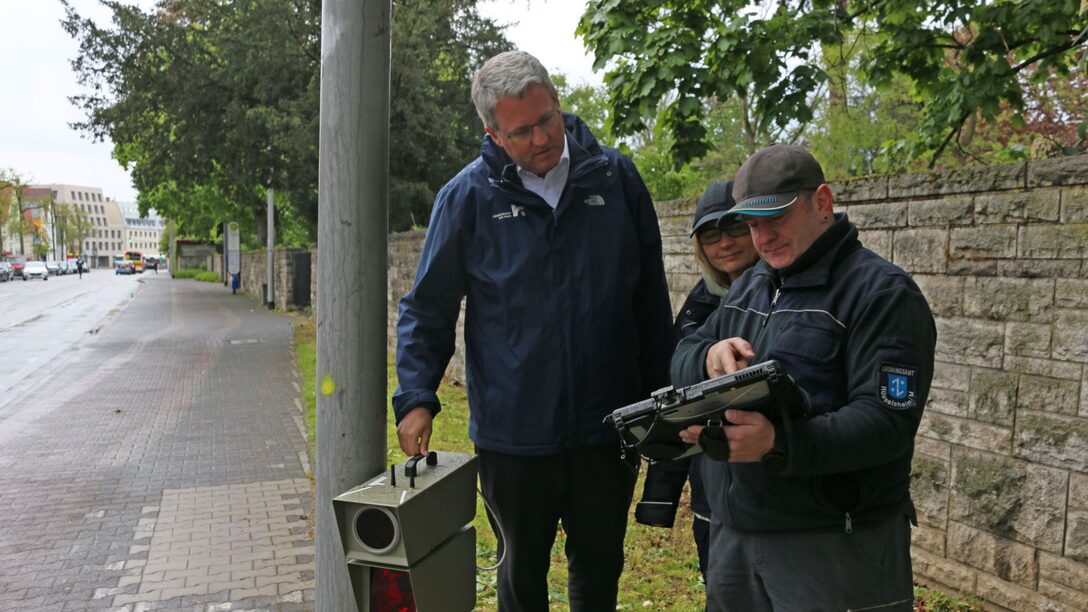 Oberbürgermeister Patrick Burghard mit Beschäftigten der Verkehrsüberwachung an einer mobile Geschwindigkeitsmessanlage