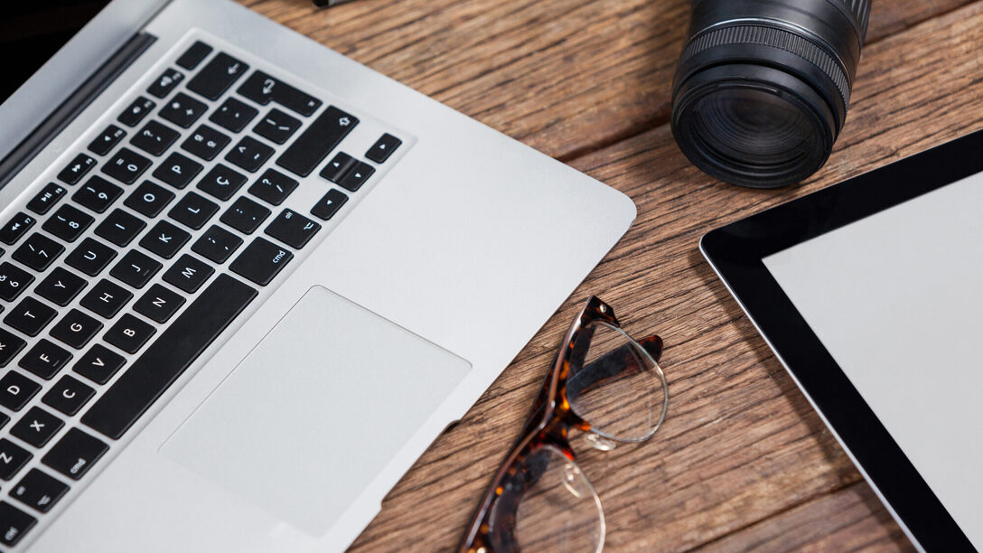 Close-up of digital camera, digital tablet, laptop, spectacle on table