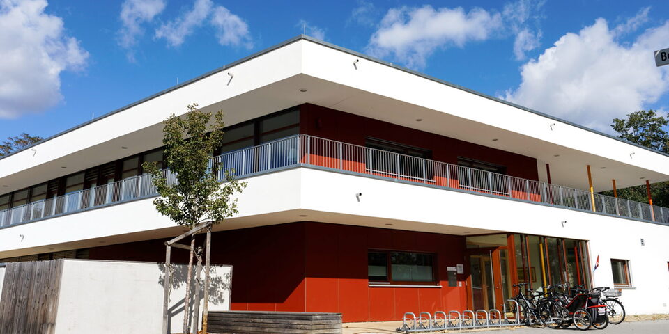 Außenansicht auf das zweigeschossige Gebäude mit Flachdach der Kita Bensheimer Straße